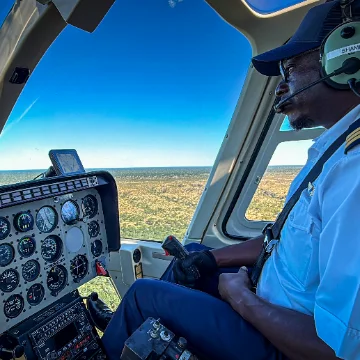 Helicopter pilot in the cockpit during a flight in Victoria Falls