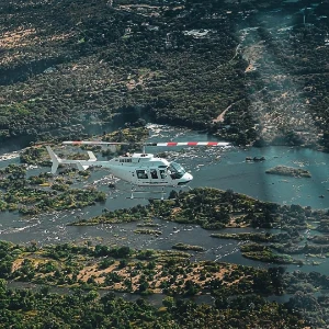 White helicopter flying above the Zambezi River near Victoria Falls