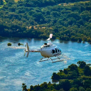 Helicopter flying low above the Zambezi River and surrounding forest